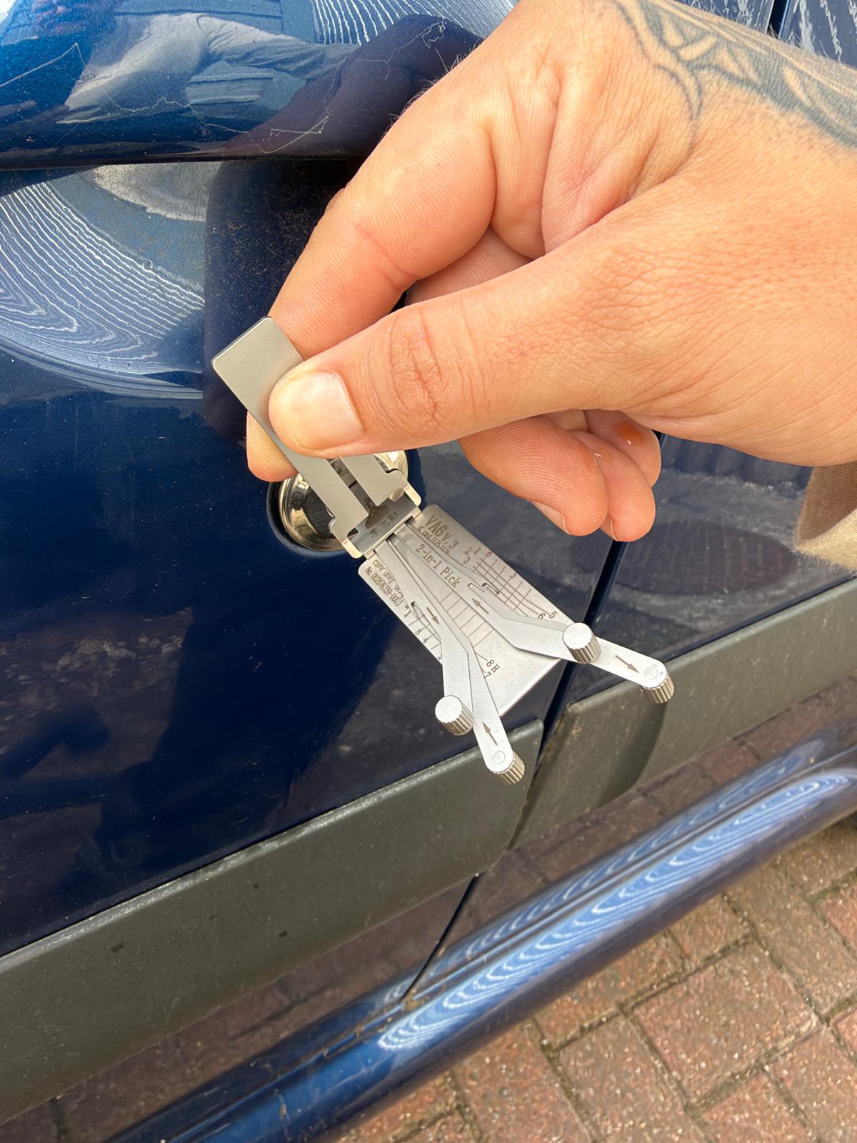 Non destructive lock opening on Renault showing hand turning silver lock pick in blue car door