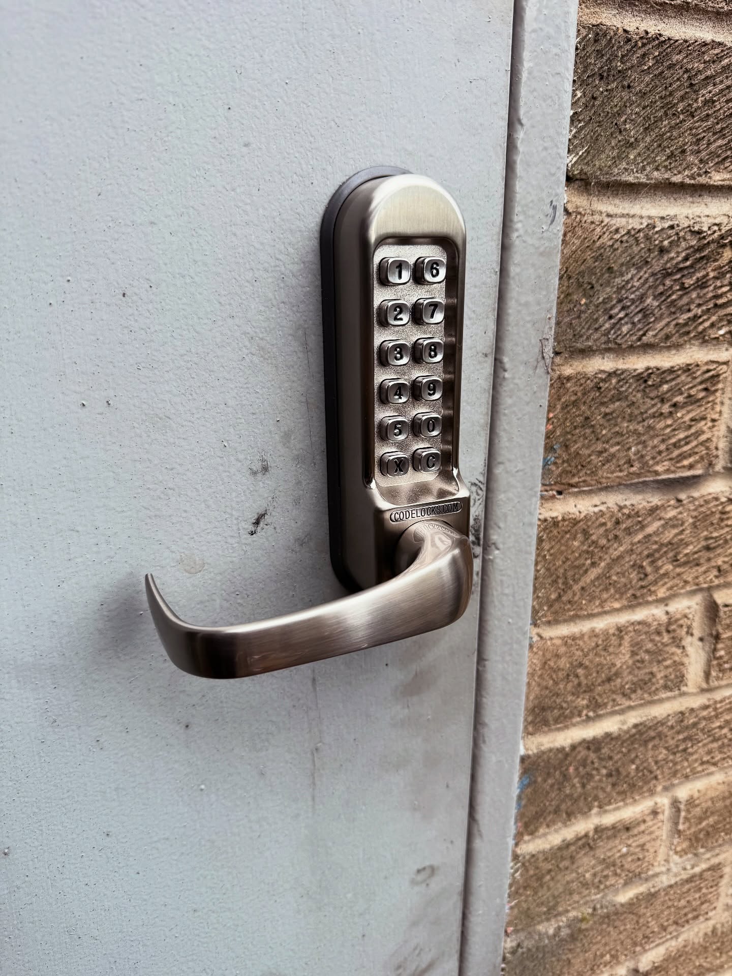 Code lock in silver fitted to metal commercial door