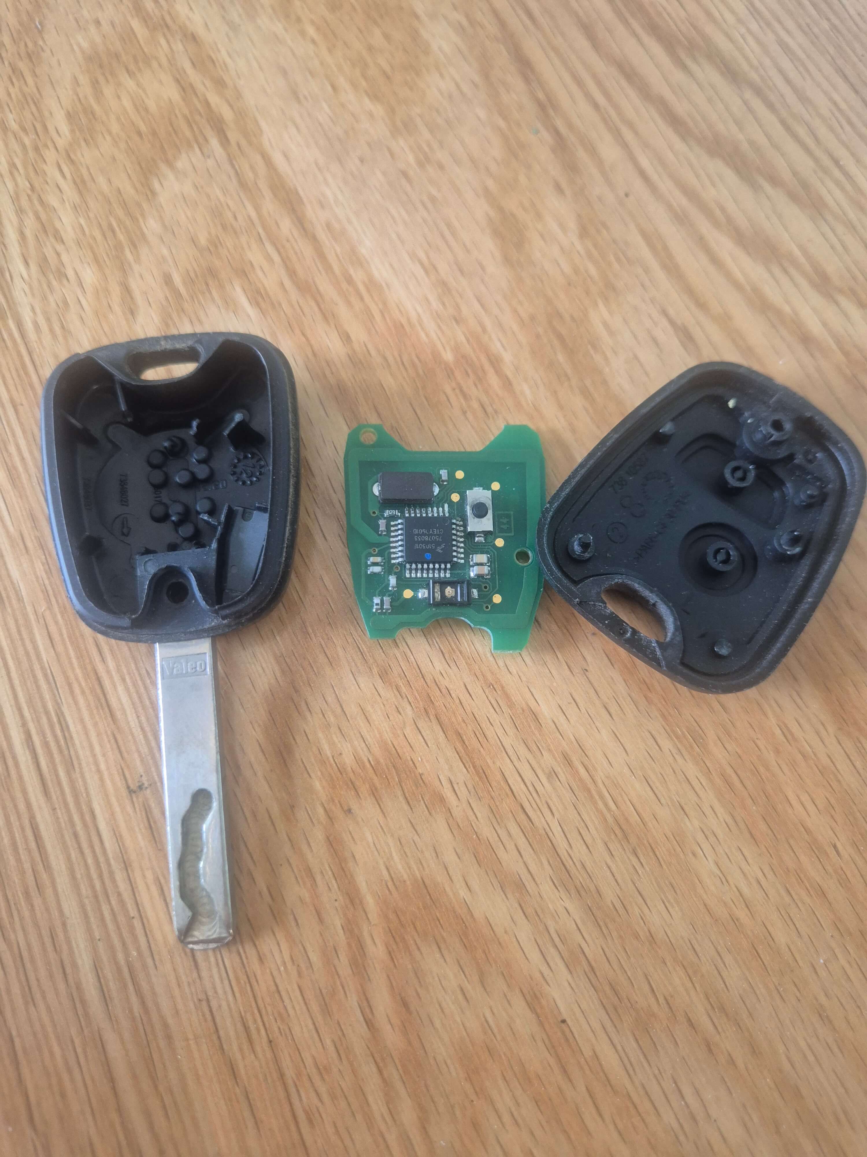 Broken citroen C1 Key fob laid on oak table with key shell and circuit board