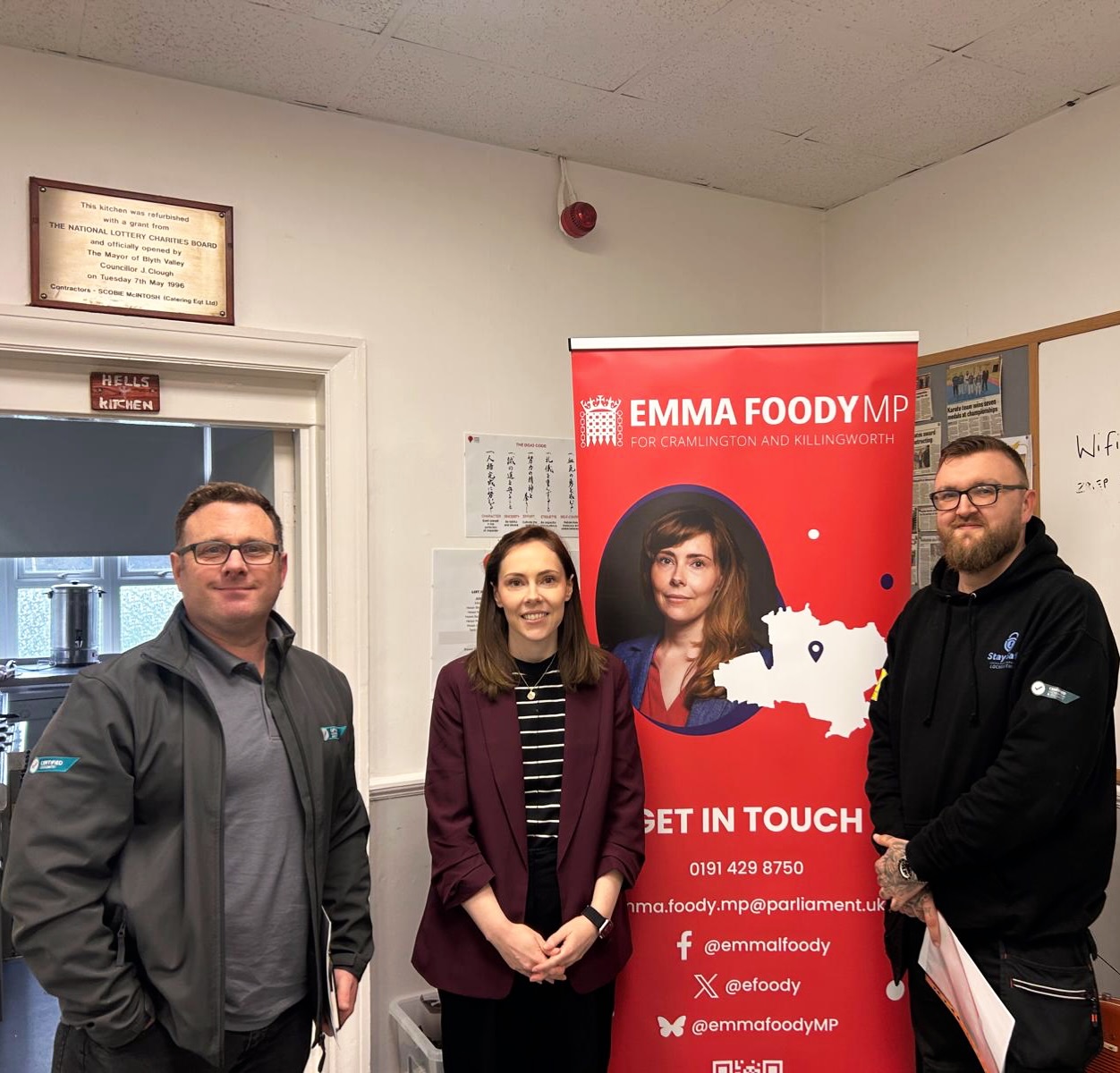 Emma Foody Member of Parliament meeting with James Revitt-Howland in front of government red banner 