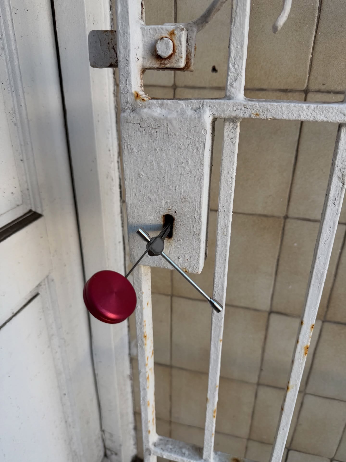 metal gate lock opened non destructively showing curtain pick with red handle 