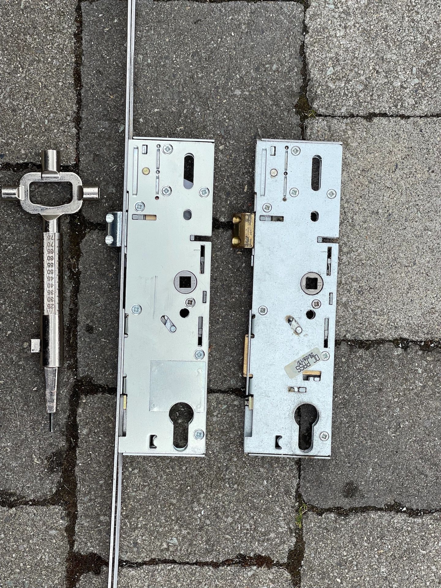 Old and new multi point lock gearboxes laid on path whilst been replaced 