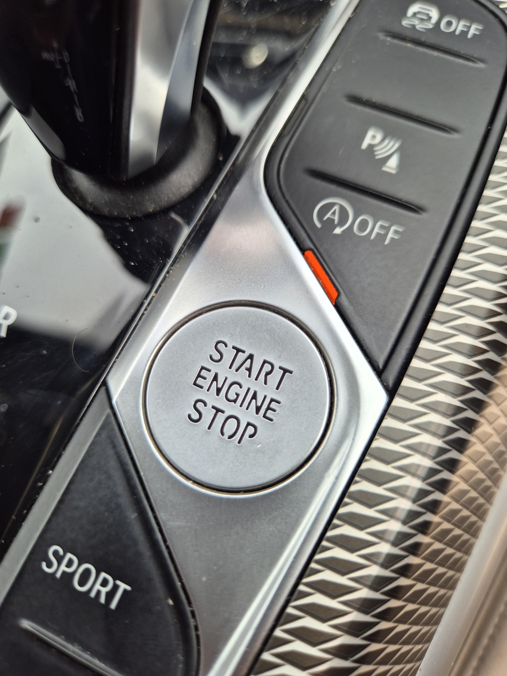 Keyless silver start button with start engine and stop written in black font
