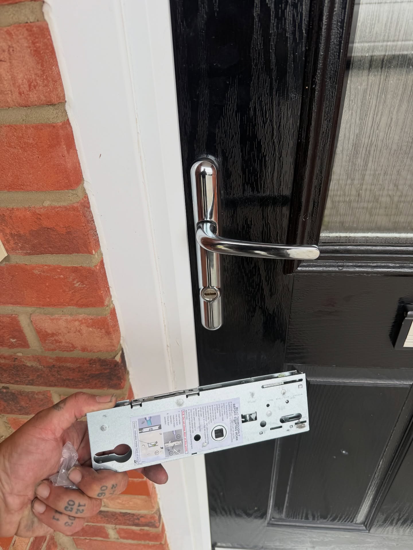 Yale YS170 gearbox being held up in front of black composite door