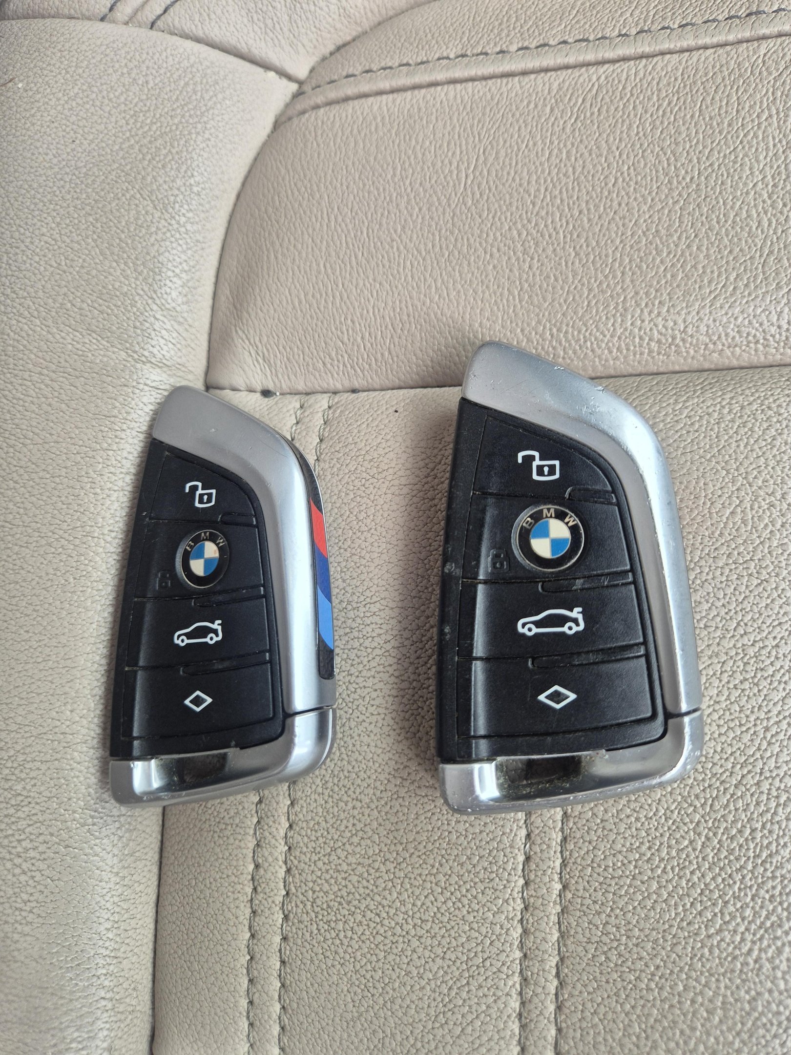2 x BMW remote keys programmed in Shiremoor laid out on cream leather seats