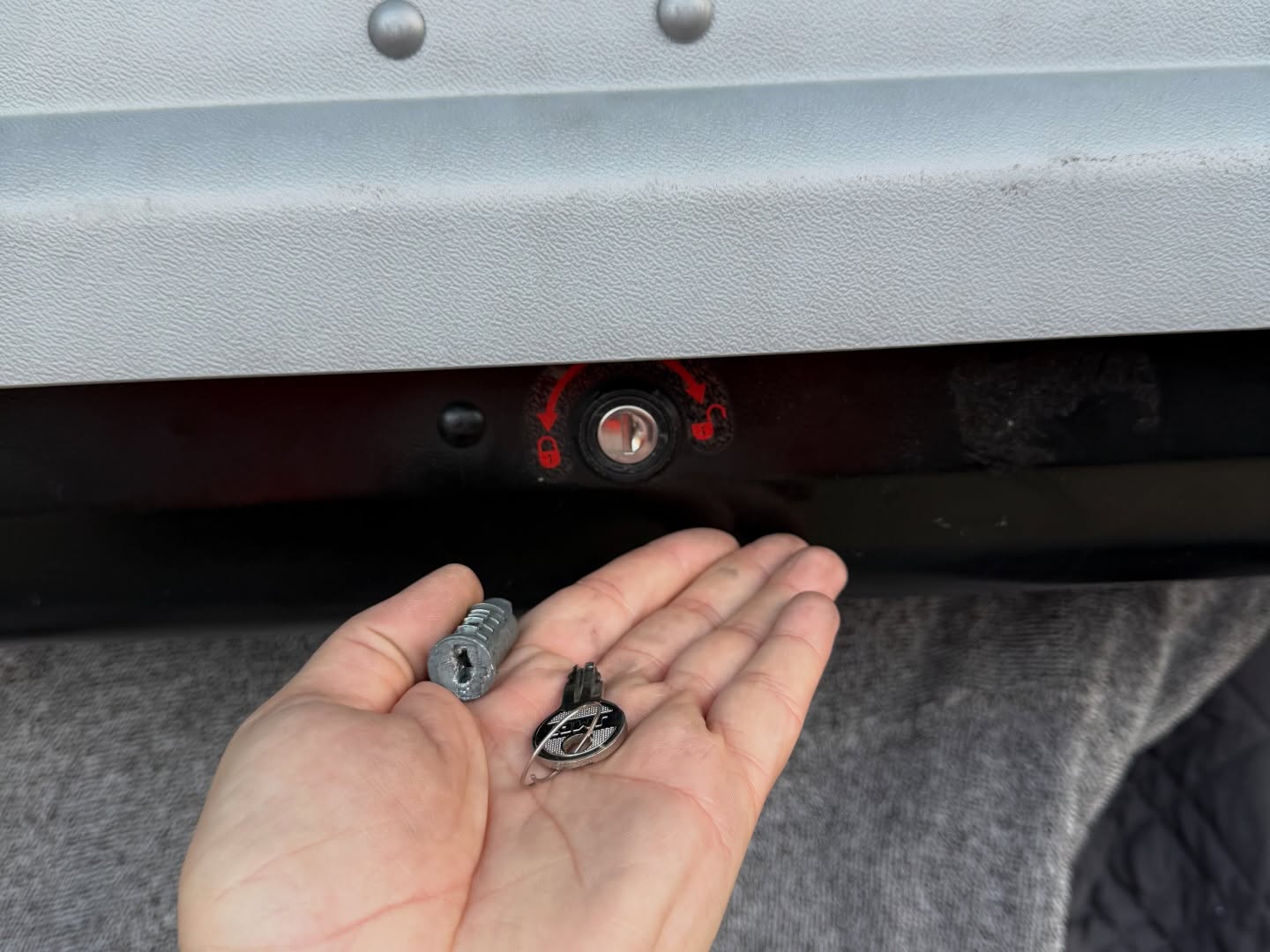 Black and grey roof box lock barrel replaced  showing both old and new barrel 