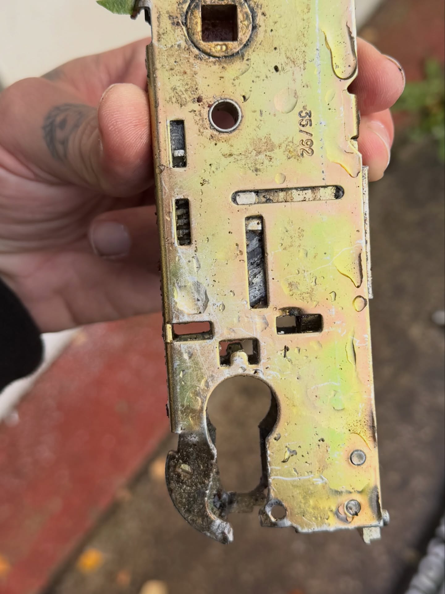 Broken multi point lock centre case being held up by hand