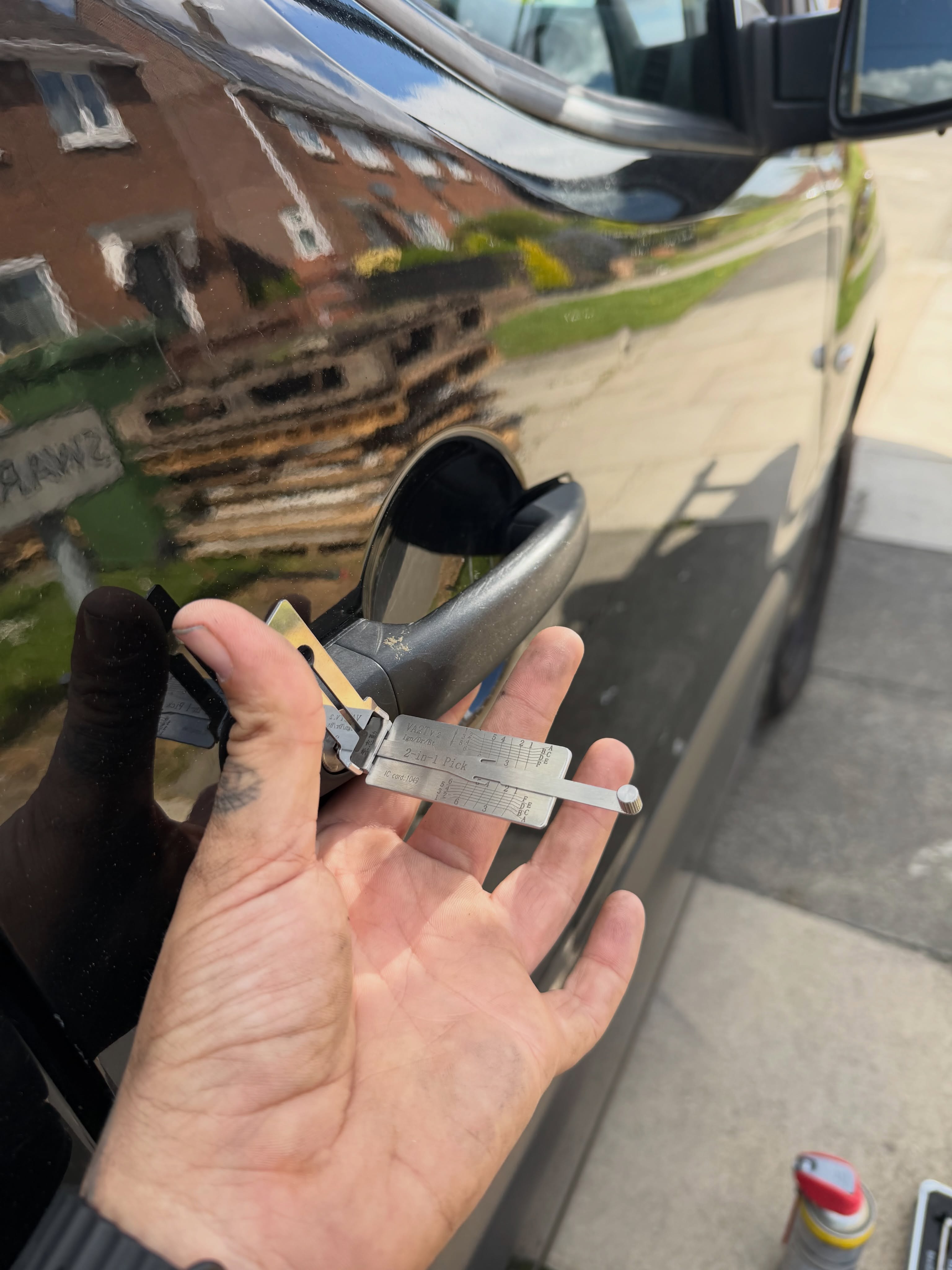James opening black van drivers door using a silver 2 in 1 lock pick