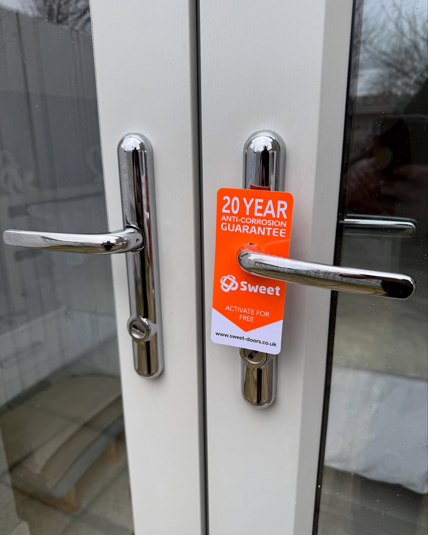 pair of chrome sweet 2 star security handles showing orange 20 year corrosion guarantee card