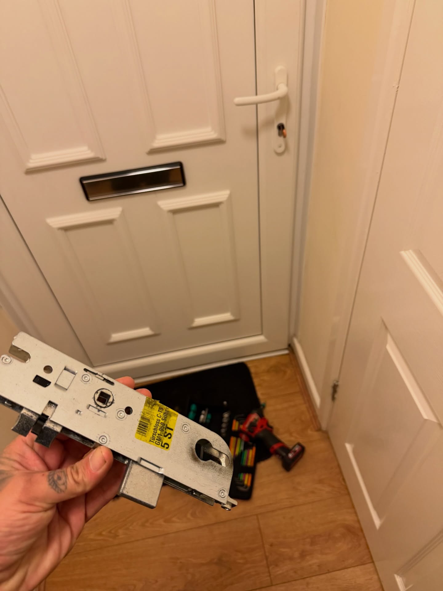 Emergency repair of white upvc door late at night showing new parts and specialist equipment